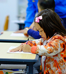 Young girl with a disability seated at school desk